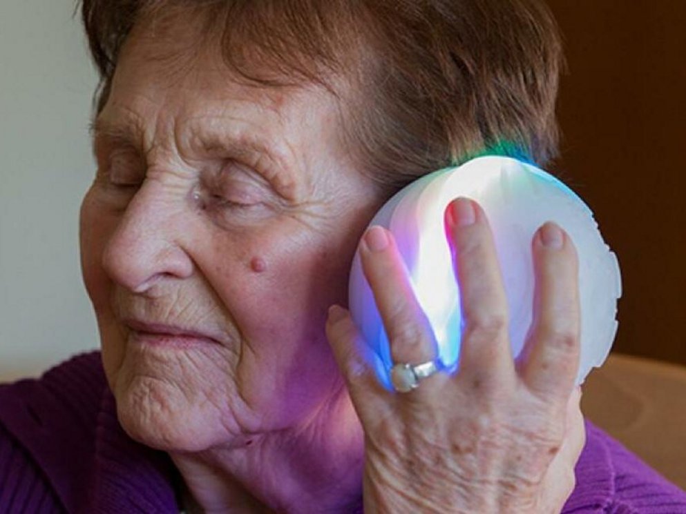 Eine Patientin tin hält ihr Ohr an den icho Ball