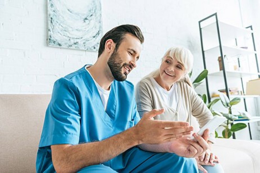 Ein Bild einer Pflegekraft neben einer Patientin